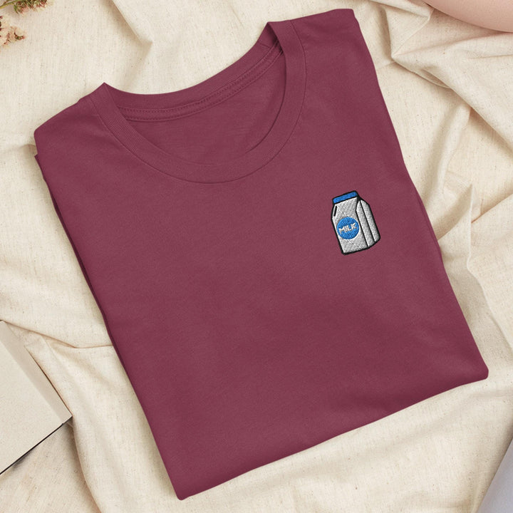 a t - shirt with a sticker on it laying on a bed