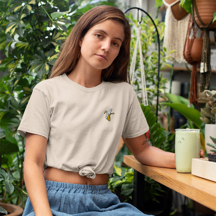 a woman sitting at a table with a plant in the background