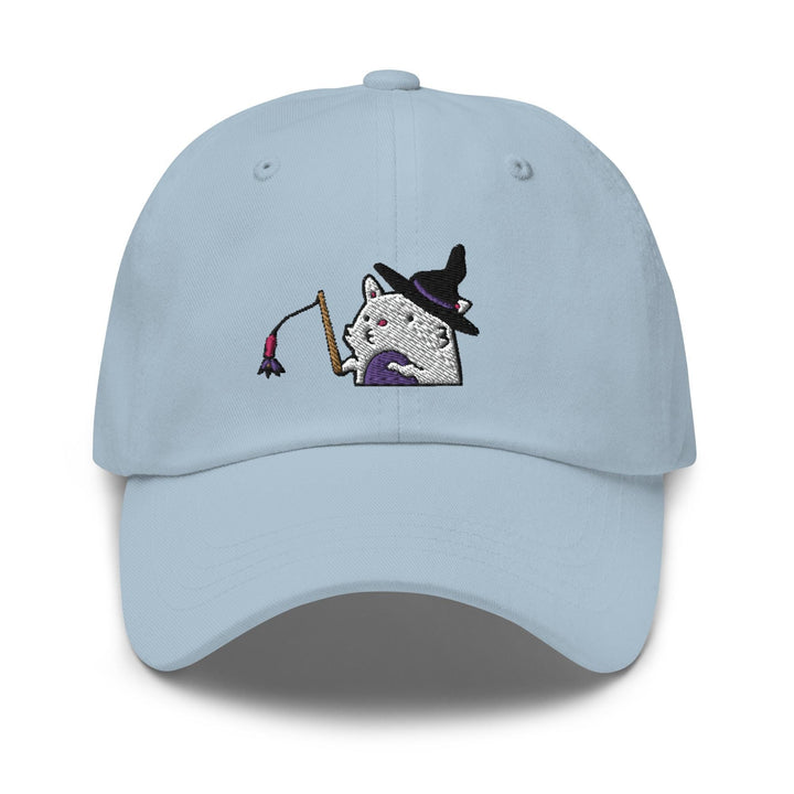 a light blue hat with a white cat wearing a witches hat and holding a broom
