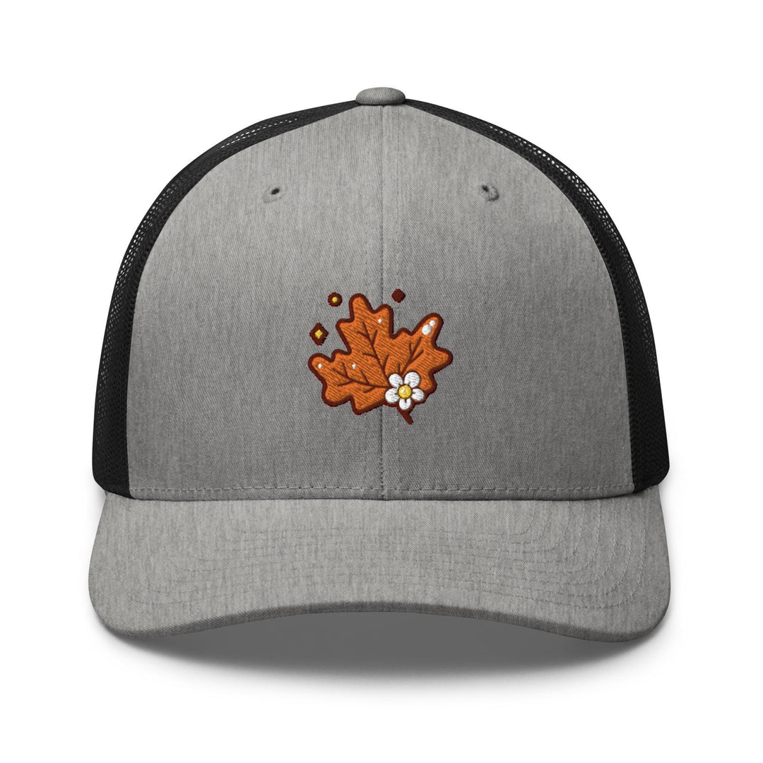 a gray and black trucker hat with an orange maple leaf embroidered on the front