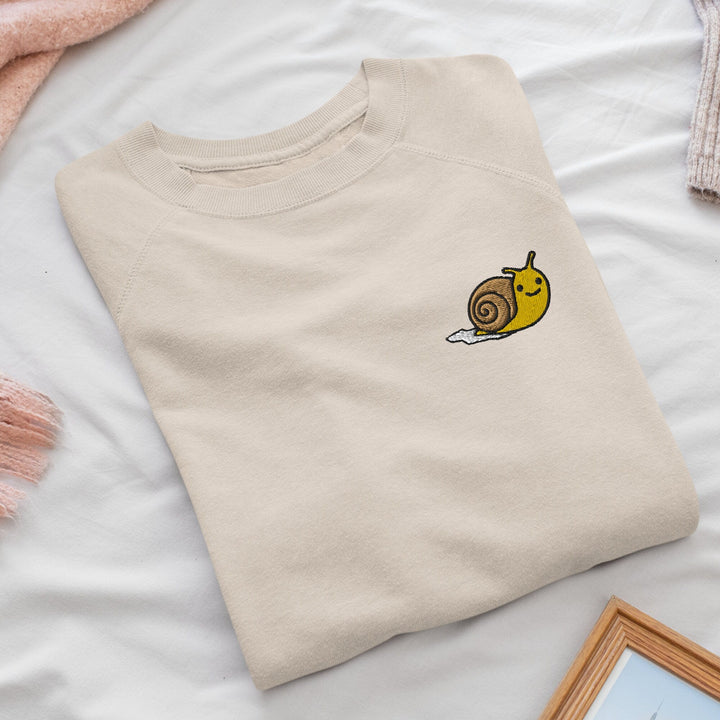 a t - shirt with a snail embroidered on it