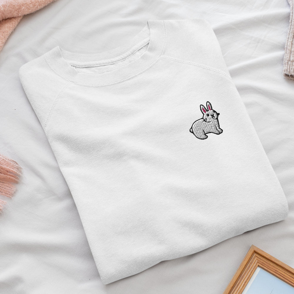 a white t - shirt with a rabbit embroidered on it