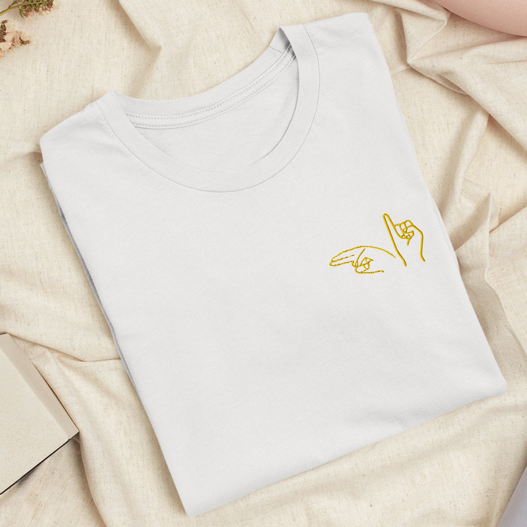 a white t - shirt with a yellow hand on it