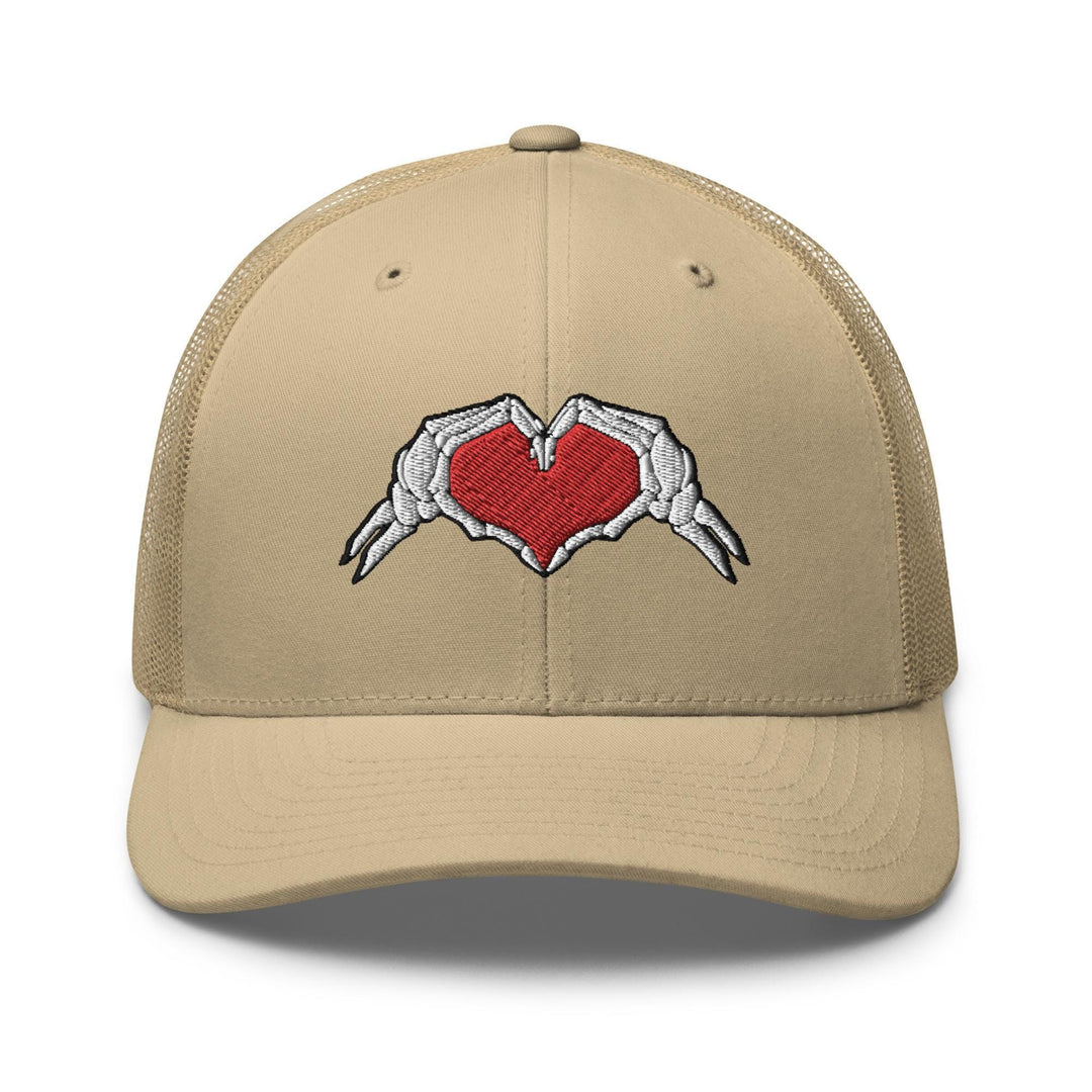 a tan trucker hat with a heart and wings embroidered on the front