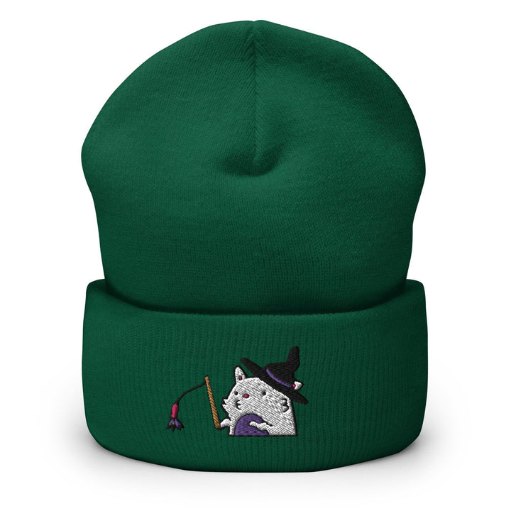 a green beanie with a white cat wearing a witches hat