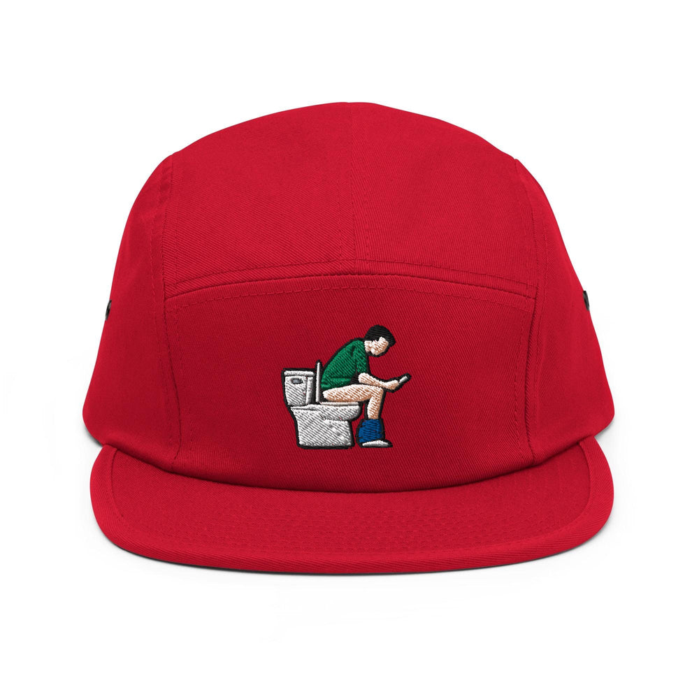 a red hat with a picture of a man sitting on a toilet