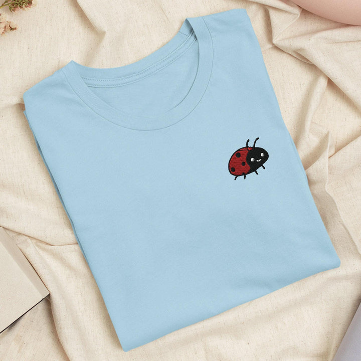 a blue t - shirt with a ladybug embroidered on it
