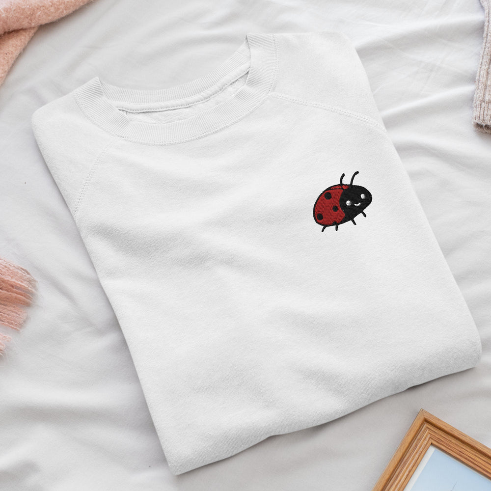 a white t - shirt with a ladybug embroidered on it