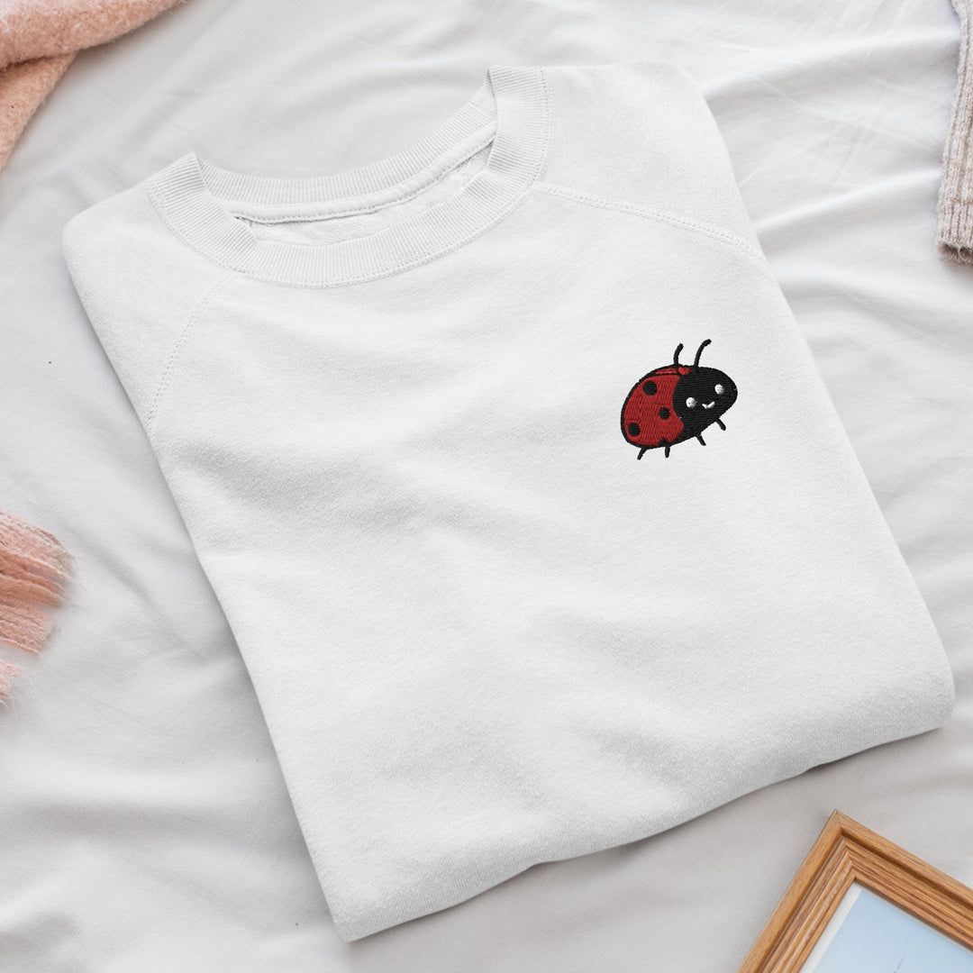a white t - shirt with a ladybug embroidered on it