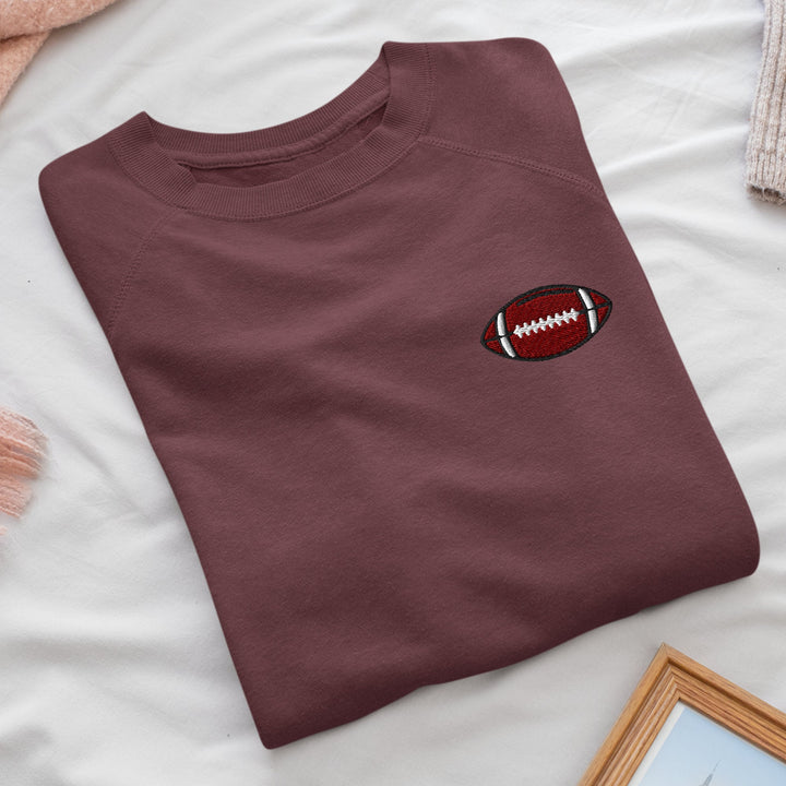 a t - shirt with a football embroidered on it
