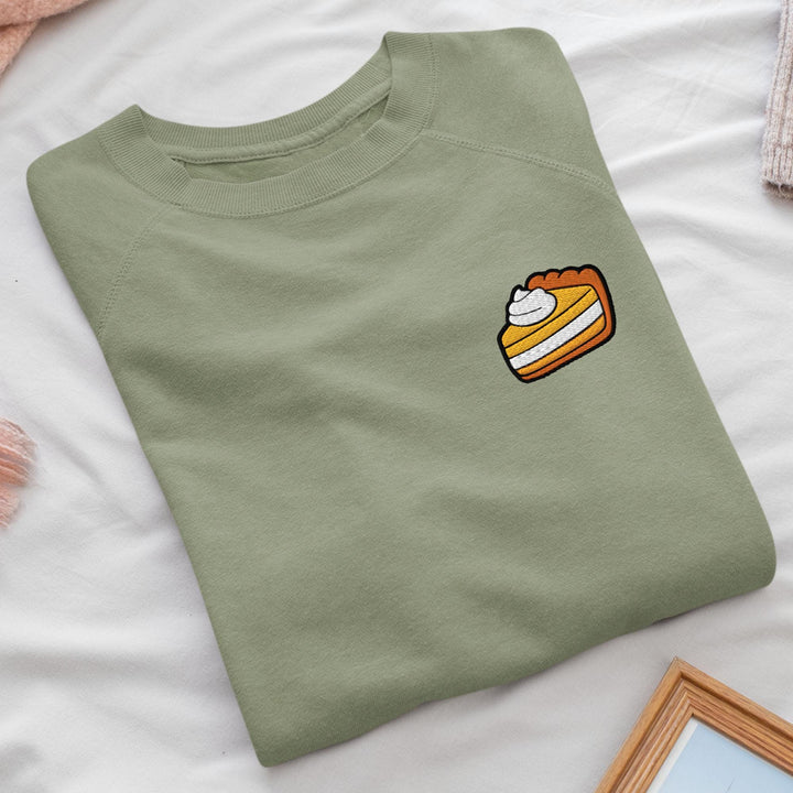 a green t - shirt with a piece of cake on it