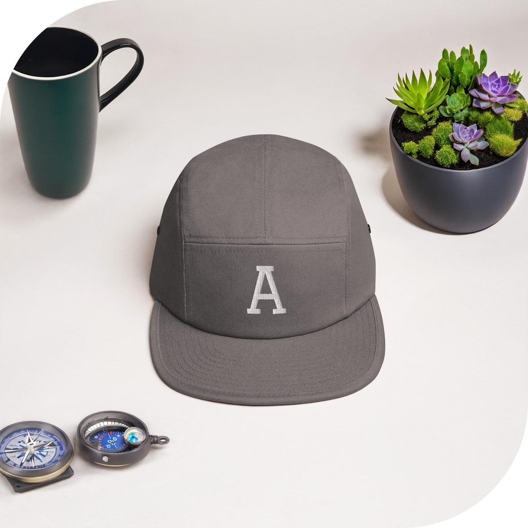 a hat, a mug, and a compass are on a table
