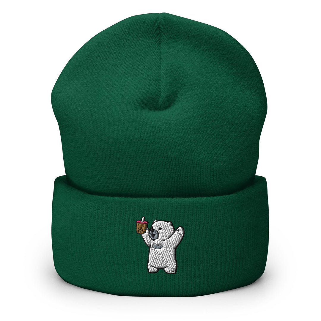 a green beanie with a white bear holding an apple