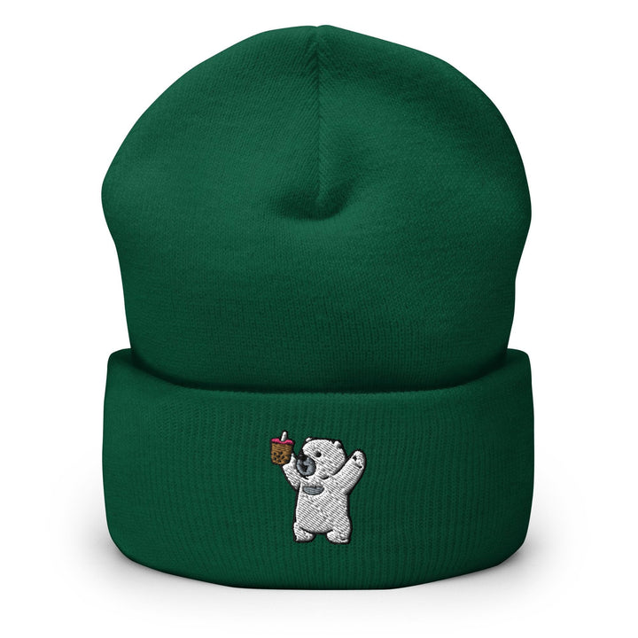 a green beanie with a white bear holding an apple