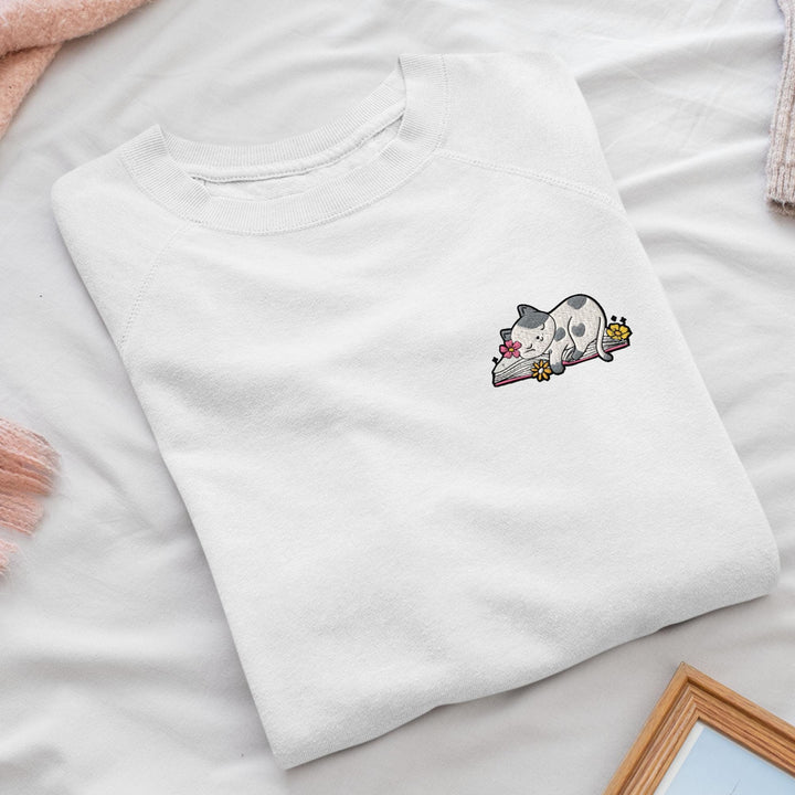 a white t - shirt with a picture of a cat laying on top of it