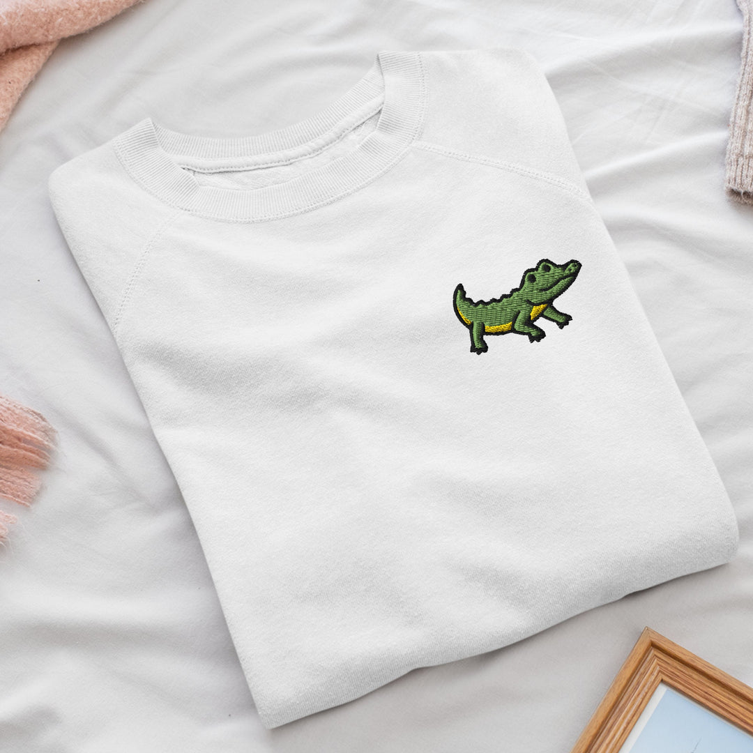 a white t - shirt with a green alligator embroidered on it