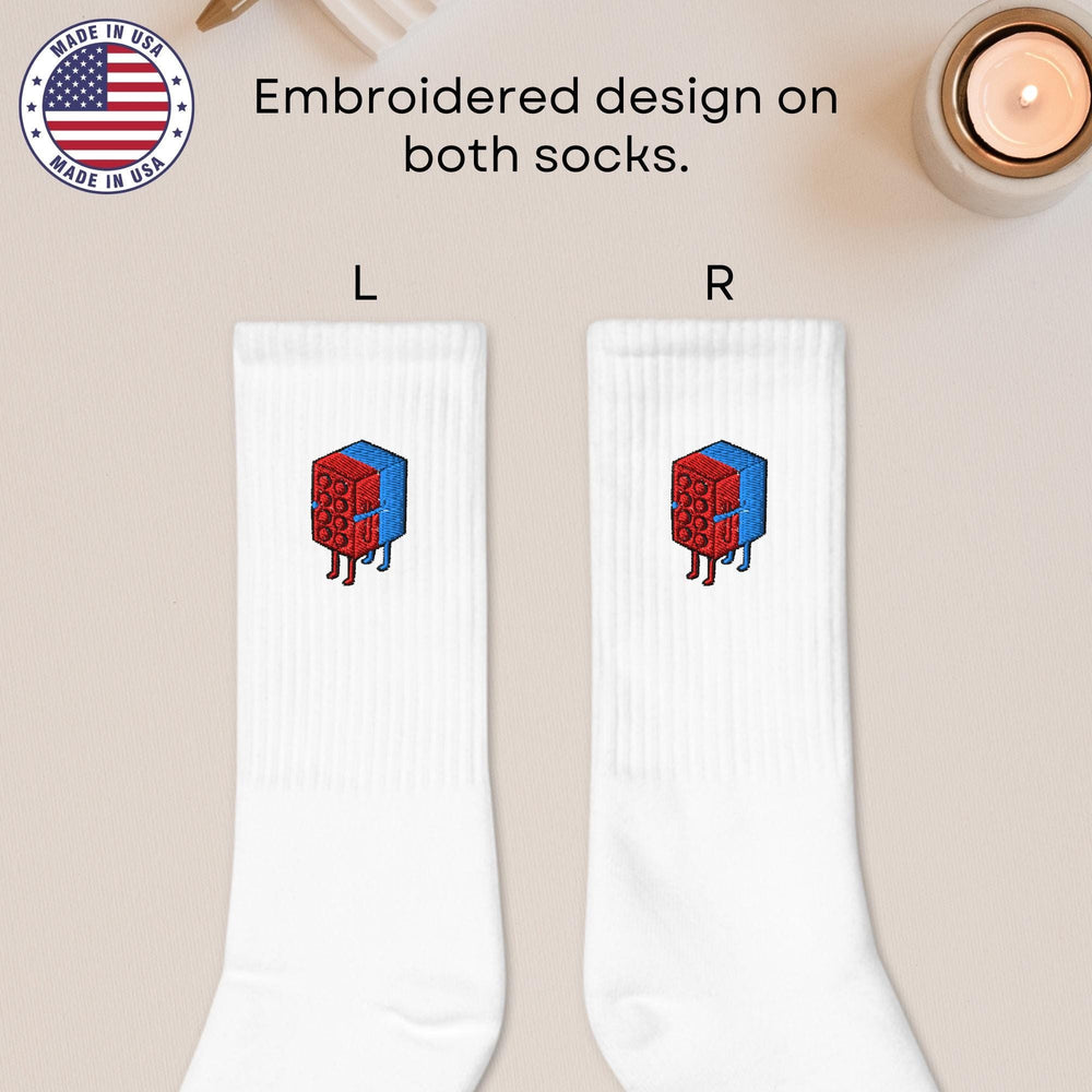 a pair of white socks with a red cube on it