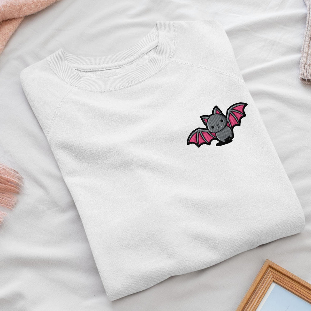 a white t - shirt with a bat embroidered on it