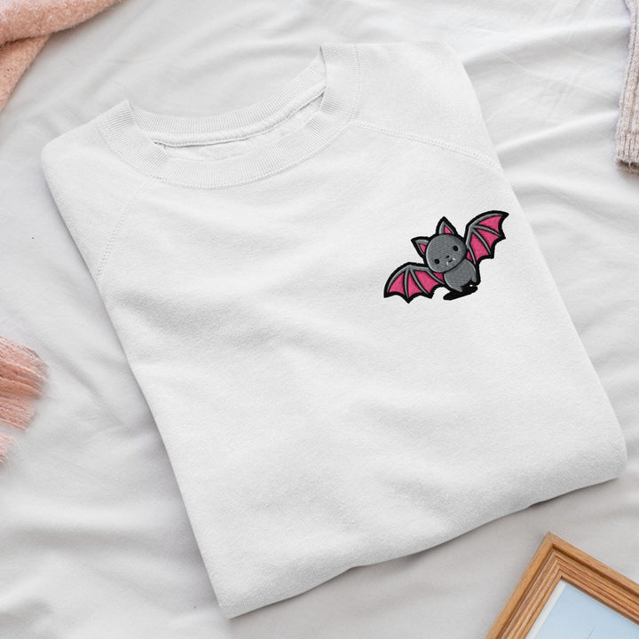 a white t - shirt with a bat embroidered on it