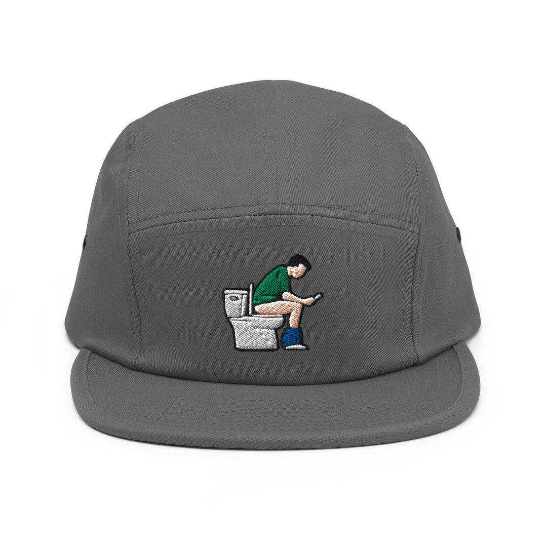 a grey hat with a man sitting on a toilet