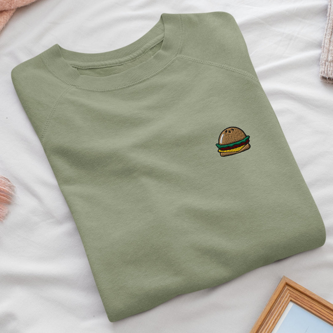 a green shirt with a hamburger embroidered on it