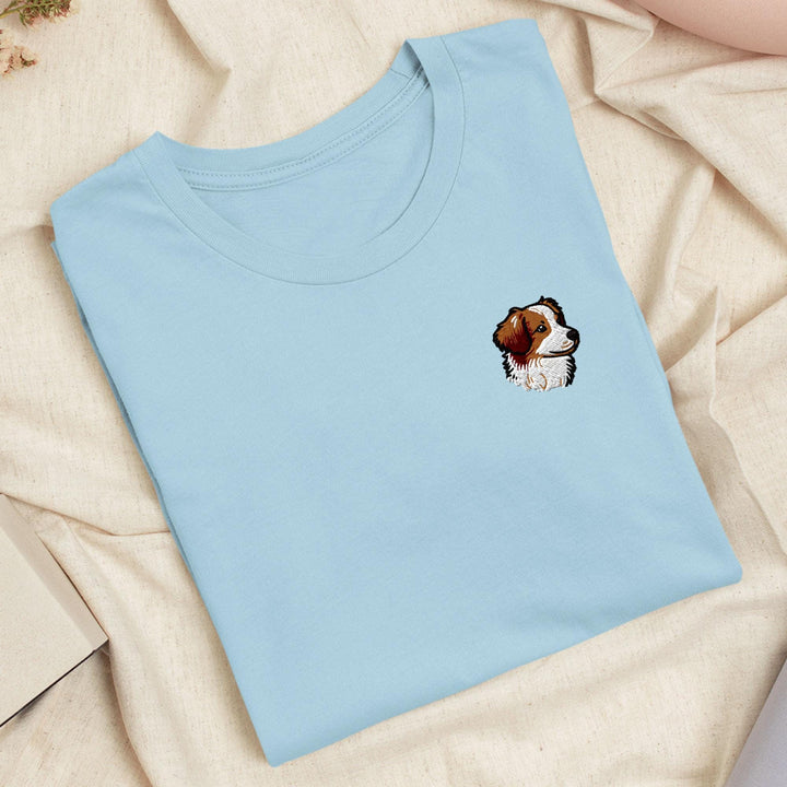 a blue t - shirt with a brown and white dog on it