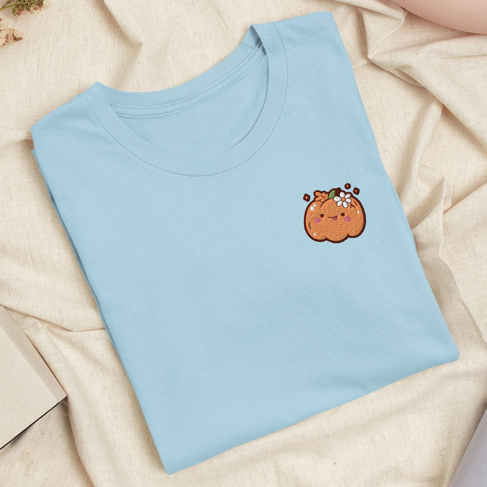 a blue t - shirt with a cartoon pumpkin on it