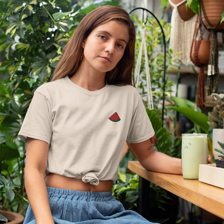 a woman sitting at a table in a greenhouse