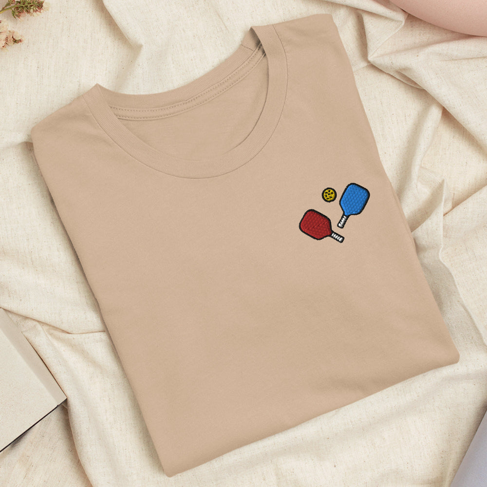 a t - shirt with a picture of a ping pong racket and ball