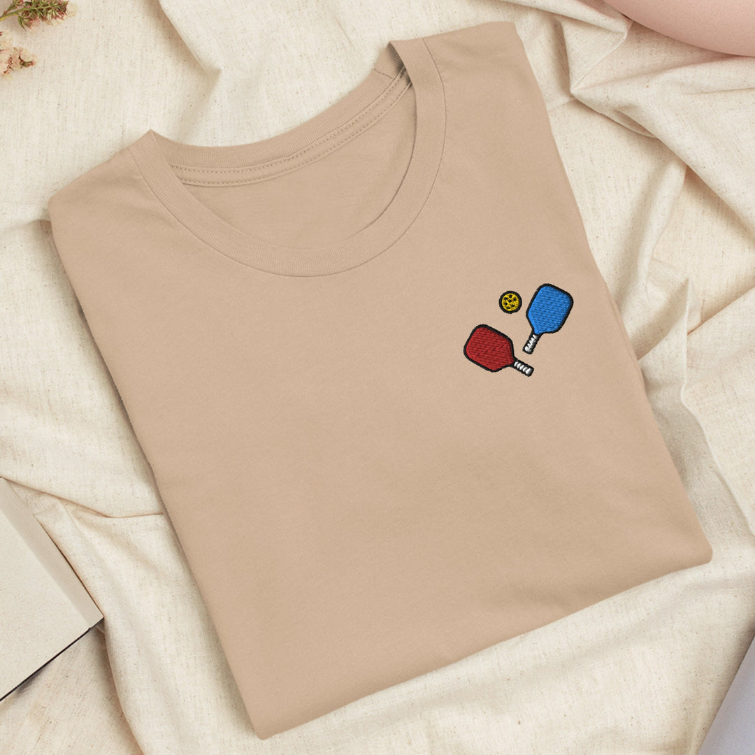 a t - shirt with a picture of a ping pong racket and ball