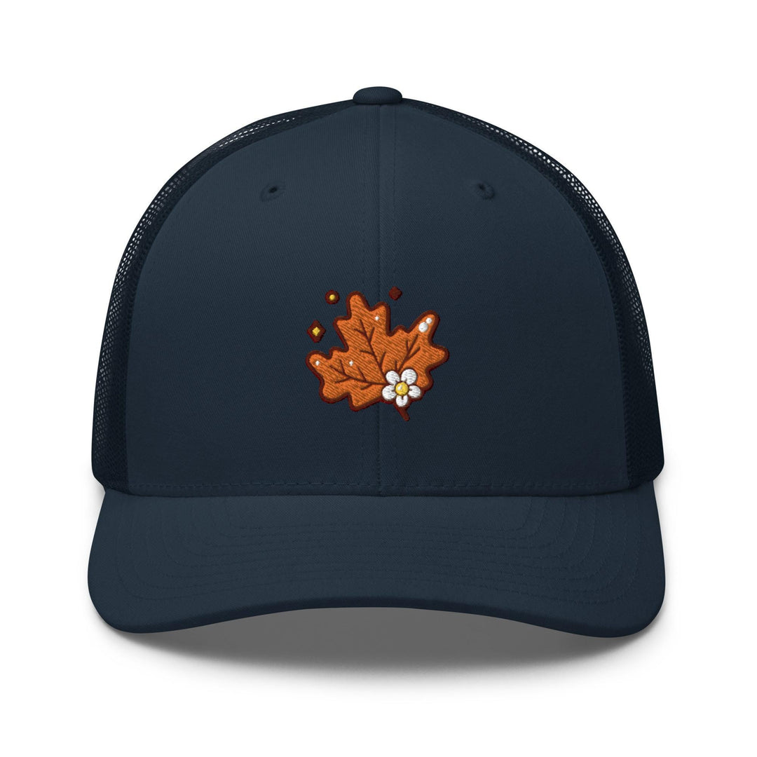 a blue trucker hat with an orange maple leaf embroidered on the front
