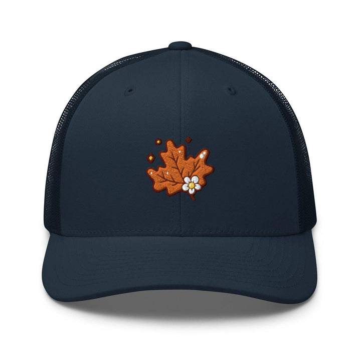 a blue trucker hat with an orange maple leaf embroidered on the front